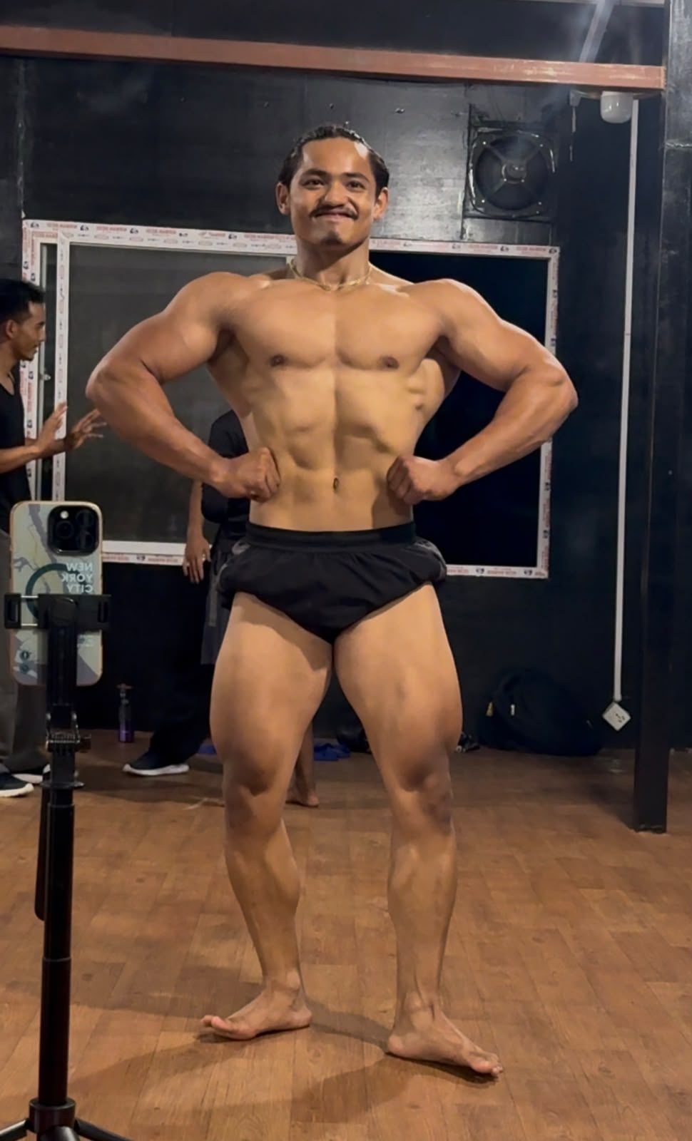 Body Workshop member flexing during bodybuilding competition prejudging