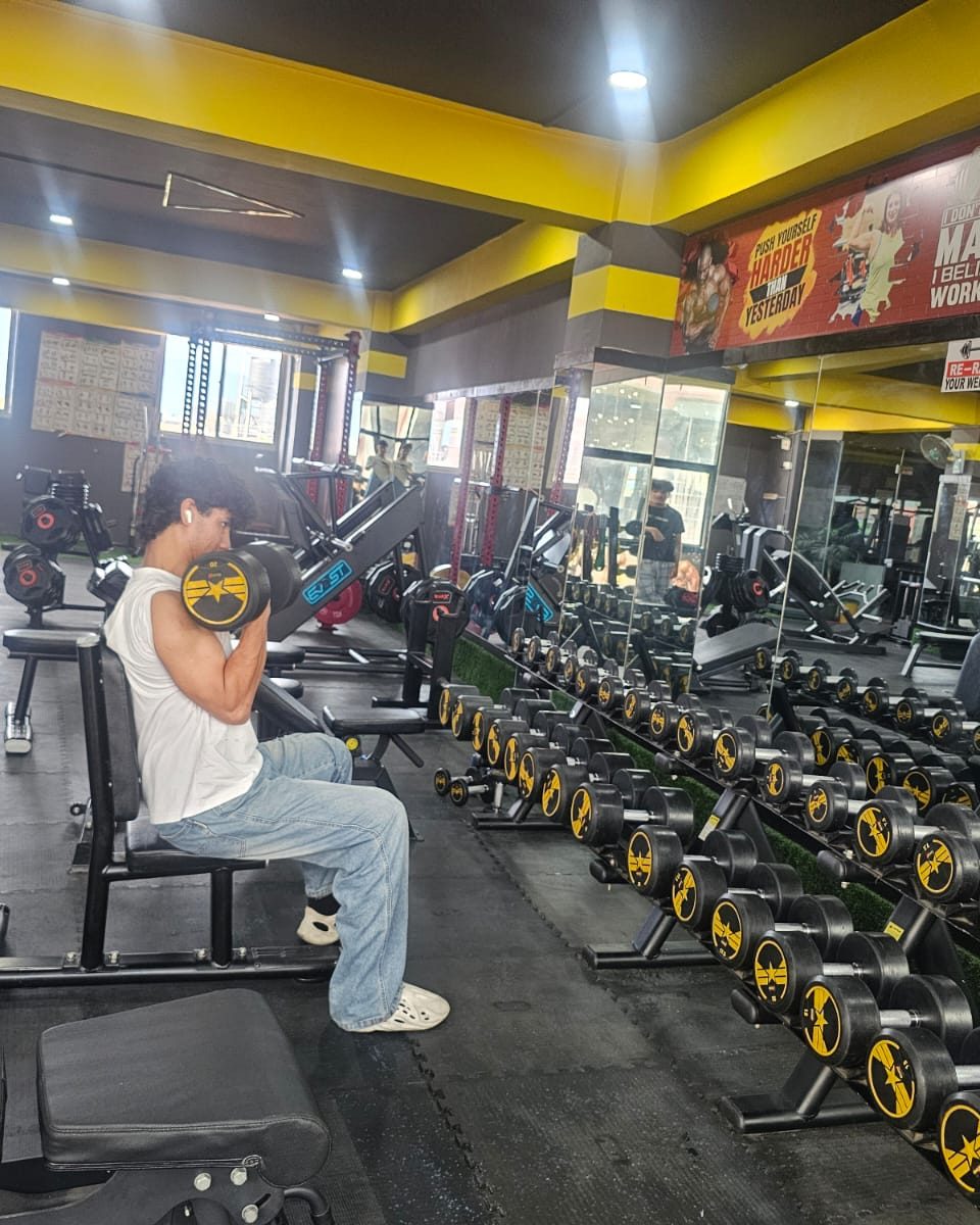 Member performing a dumbbell curl during a personal training session at Body Workshop